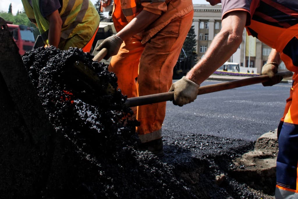 Asphalt crew laying fresh pavement